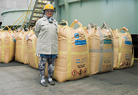 Ms. Takagi with raw materials that have just been delivered to the Niihama Nickel Refinery