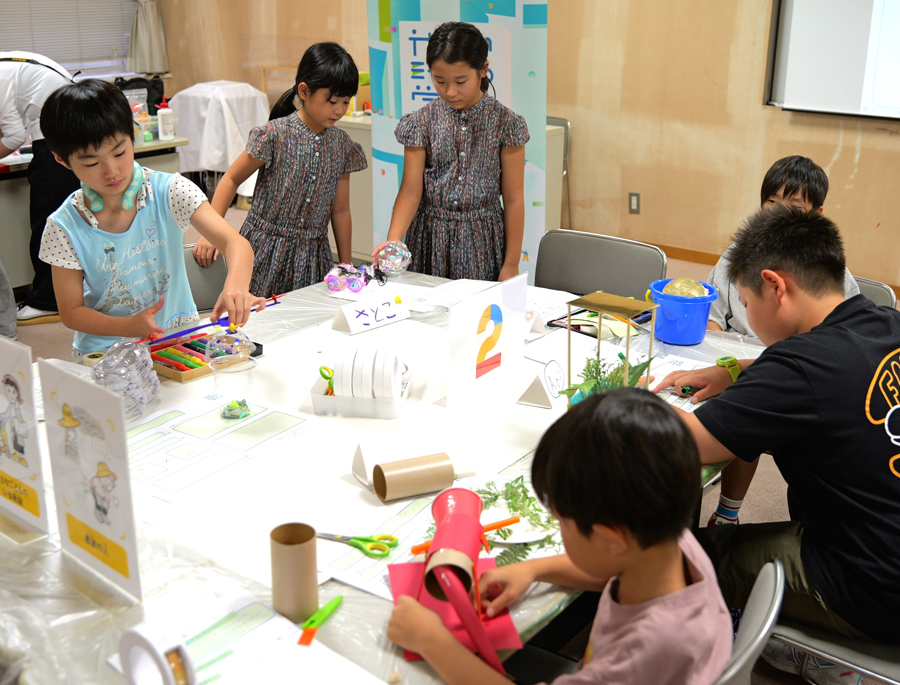 Children crafting objects with various materials