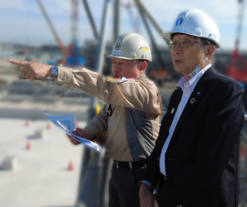 Mr. Kuniharu Nakamura, Chairman of the Sumitomo EXPO2025 Promotion Committee (right) confirms the progress of construction of the Sumitomo Pavilion, accompanied by Mr. Yutaka Tomoura, General Manager of Sumitomo Mitsui Construction-Sumitomo Forestry Special Joint Venture (left)